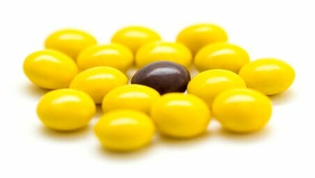 Brown skittle among yellow skittls