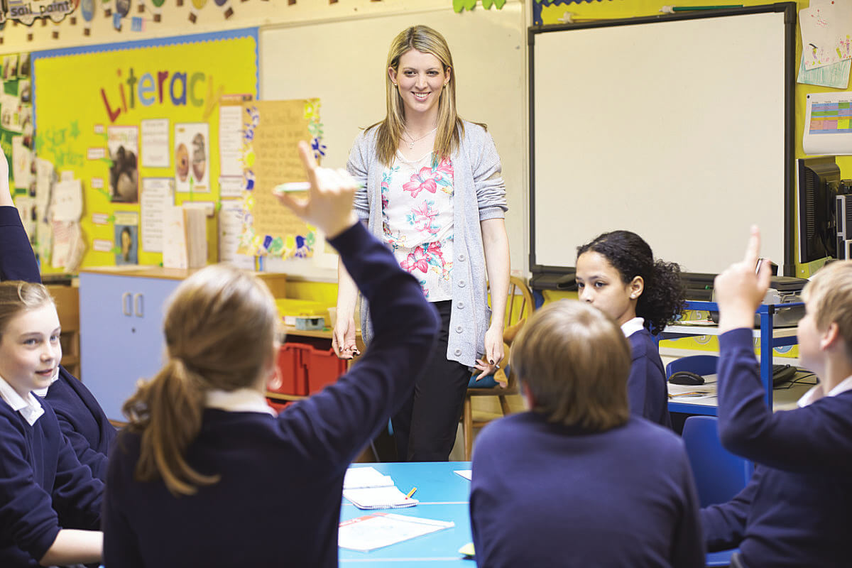 A teacher in front of a group of students in a classroom